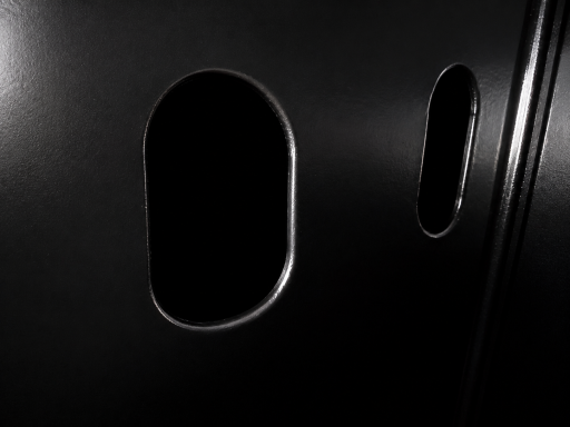 Two oval openings in a black surface, one above the other.