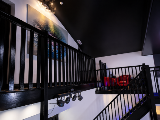 Interior view of a modern space featuring a staircase and a prominent art piece.